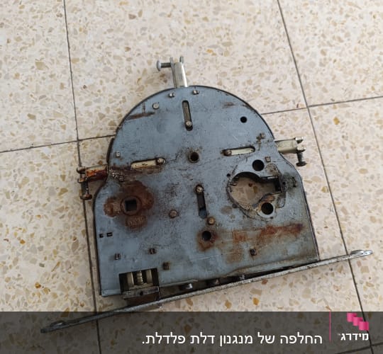 מנגנון מנעול מתכתי ישן עם חלודה על רצפה